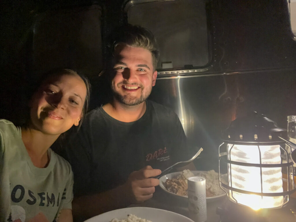 Hannah and Cody eating dinner outside an airstream at Autocamp Yosemite