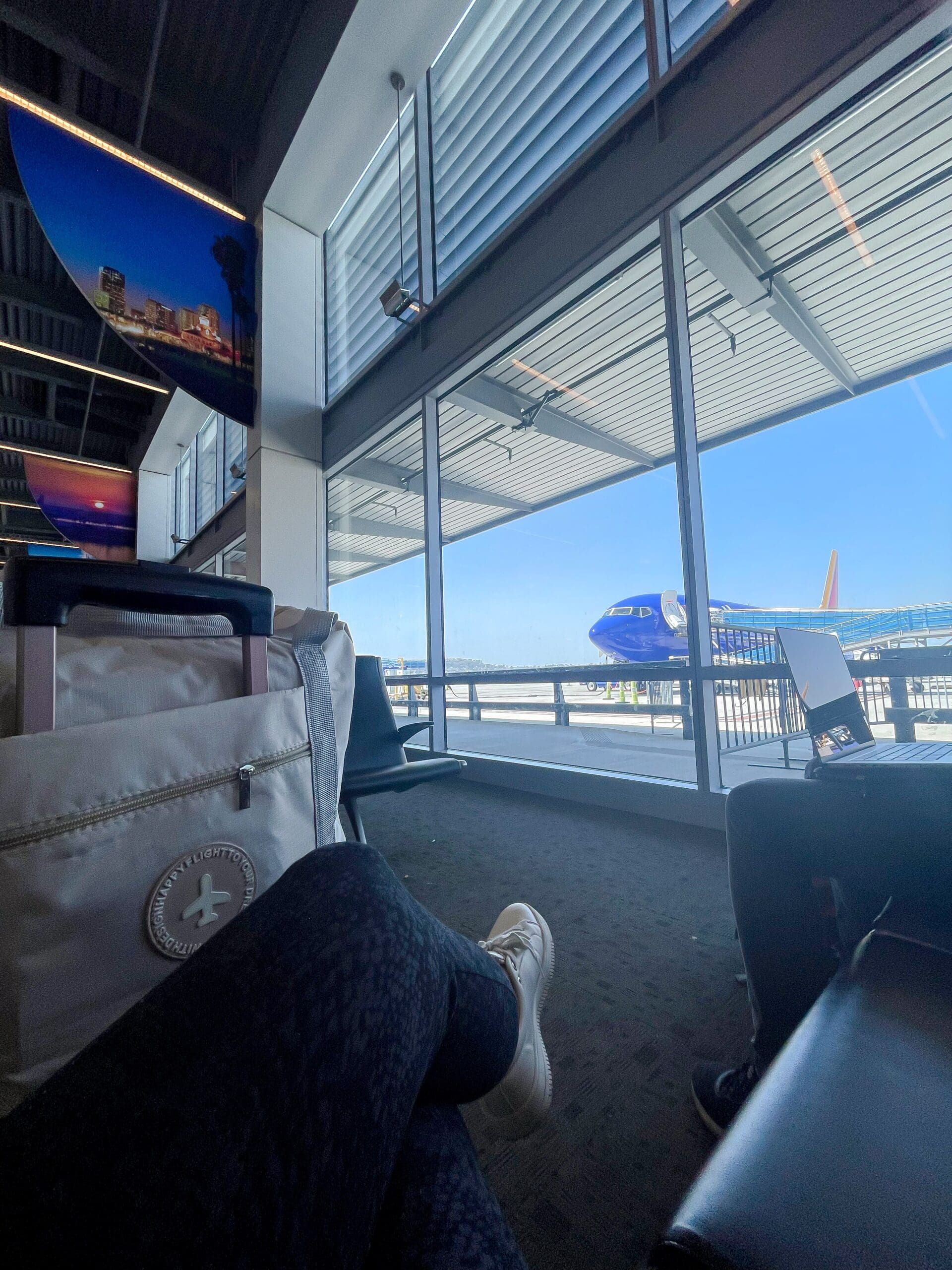 Giirl with luggage at airport with Southwest plane in background