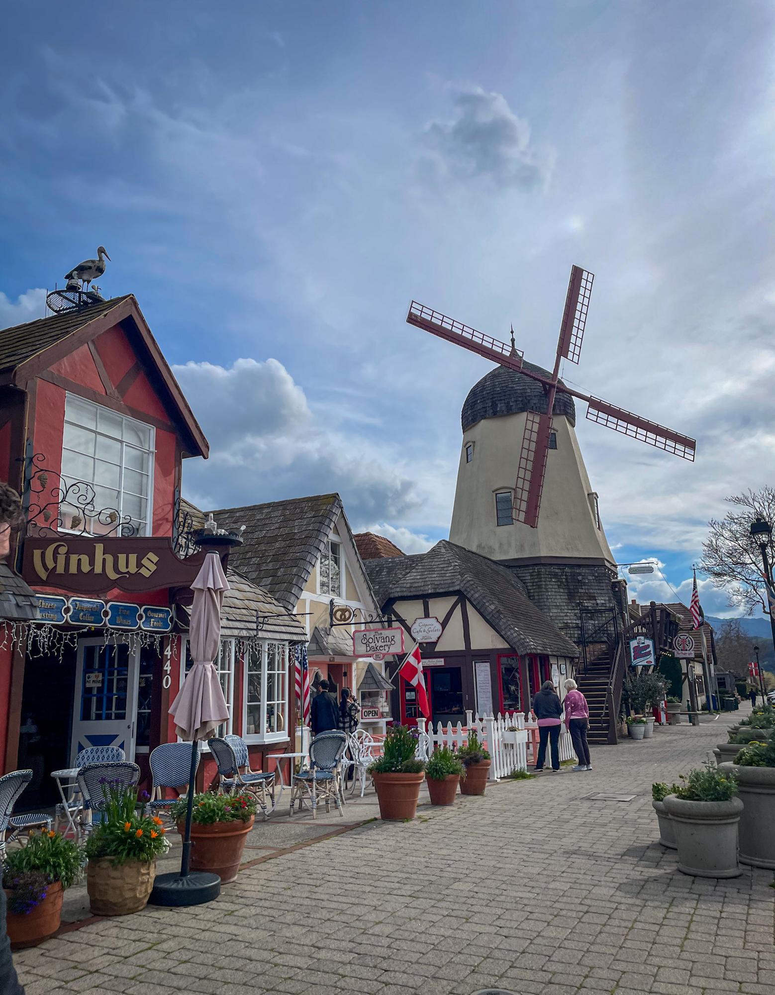 Windmill and cobblestone street with shops in Solvang