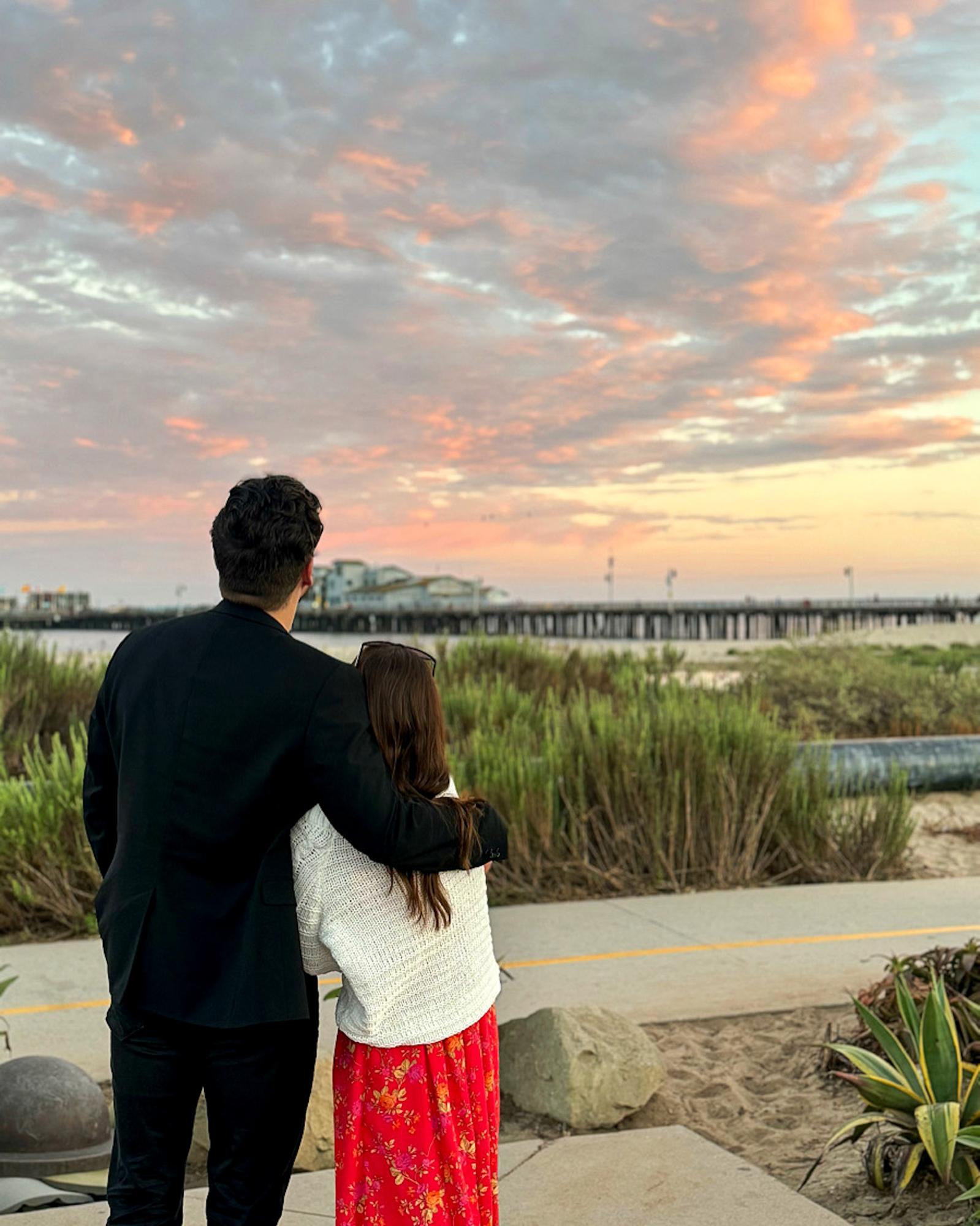 man and woman in front of sunset on the pier in Santa Barbara